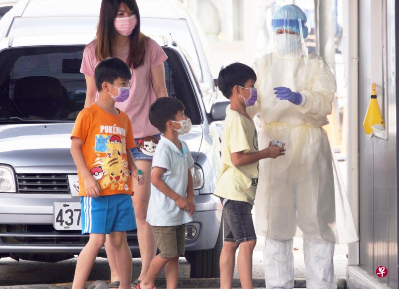 台湾昨天新增3万6168例冠病本土病例，另增10例死亡、87例中重症，儿童确诊病例也在攀升。图为高雄一位妈妈带着小孩前去进行核酸检测。（香港中通社）