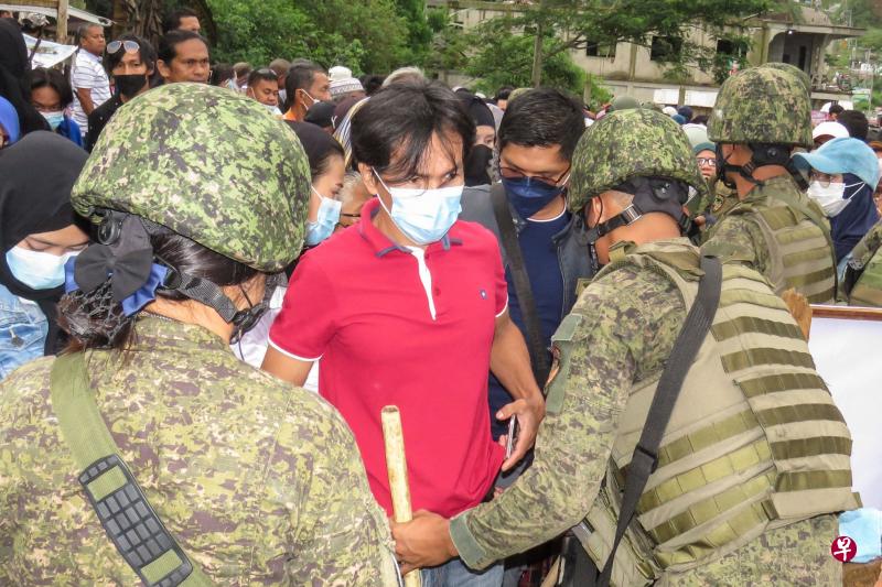 菲律宾军警派出10万名军警人员到全国各地高危的投票站驻守，以确保投票安全。图为军方在棉兰老岛马拉威市投票站进行安检。（法新社）
