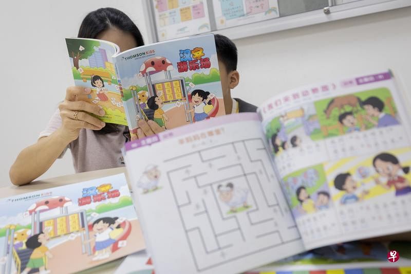康盛培育中心推出127页的中文活动本，包括漫画、有趣的故事情节、活动页，以及录音等互动内容。今年10岁的约瑟夫（右）在中心报读华文辅助课程，通过活动本学习中文。（陈来福摄）