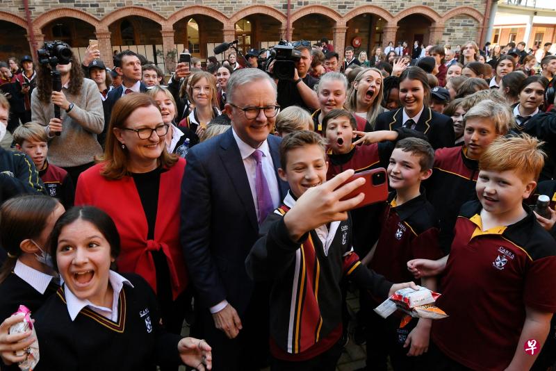 　反对党工党党魁阿尔巴尼斯昨天到阿德莱德的卡布拉多米尼加学院访问，他站在举着手机的学生后面，与他们自拍。（路透社）