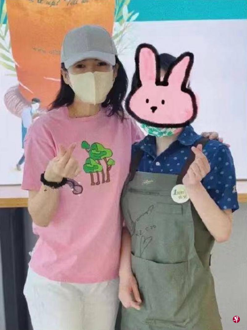 章子怡（左）和店主妹妹合影留念，比爱心手势。（互联网）