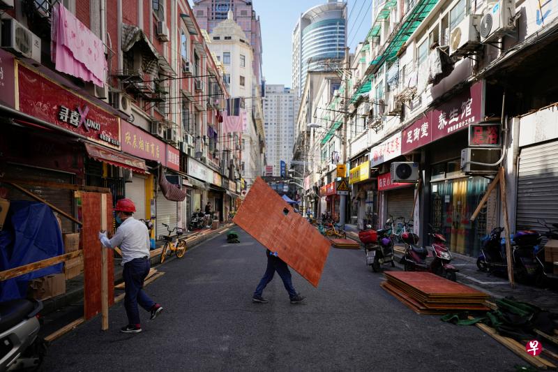 上海解封前夕，工人将用于隔离居民区的木板一一拆除。（路透社）