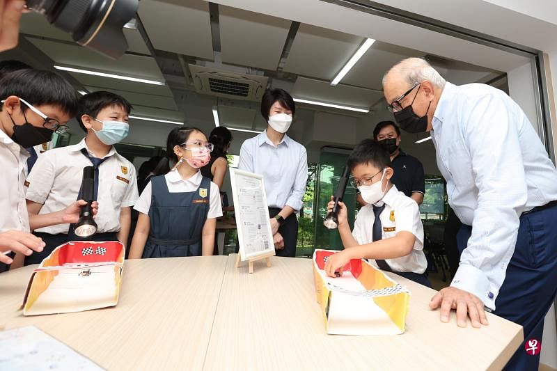 立化小学的学生参加工作坊，向交通部长易华仁（右一）解说太阳能汽车模型的运作 。（王彦燕摄）