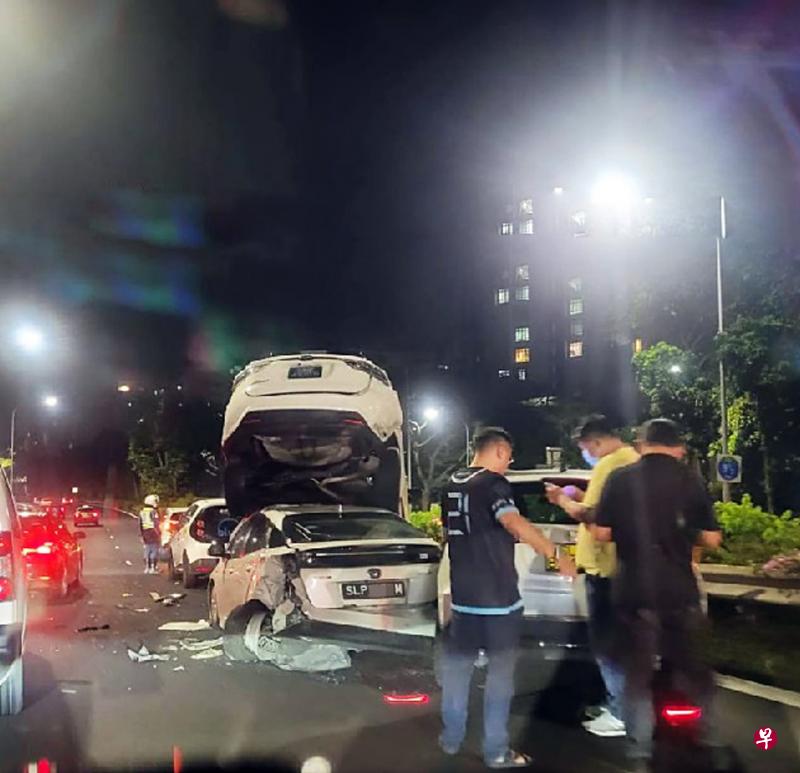 一辆白色丰田休旅车在激烈撞击下车尾翘起，叠压在另一辆白色丰田汽车车顶。（新加坡公路意外网页面簿）