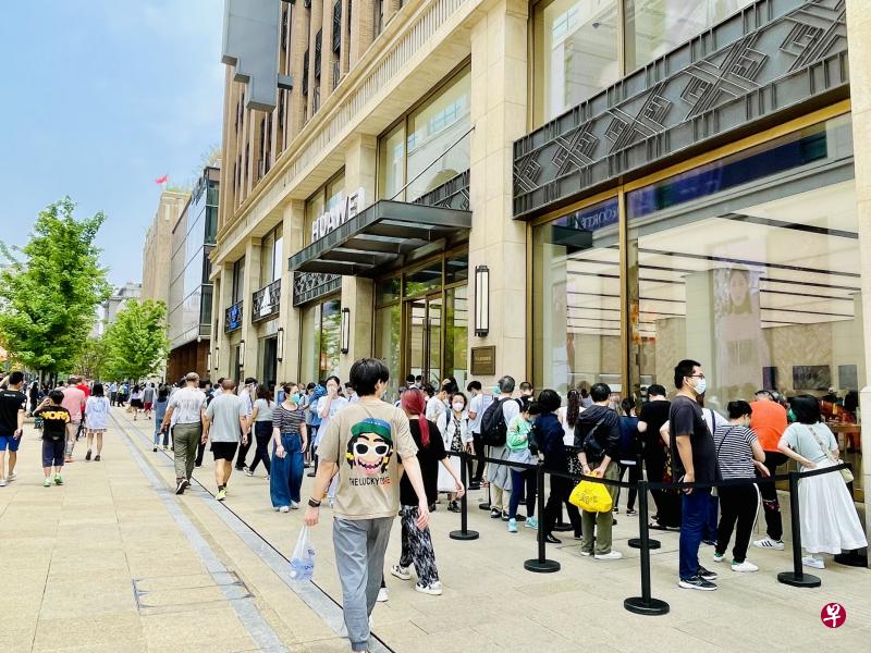中国科技巨头华为在上海市中心南京路步行街上的专卖店严格限流，等待入内的顾客大排长龙。（陈婧摄）