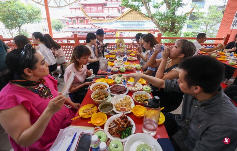 媒体人员昨天提前品尝“10个头手一桌菜”的小贩美食。（陈渊庄摄）