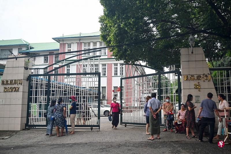 缅甸学校周四重新开学，一些家长在校园外等候为孩子报名。（法新社）