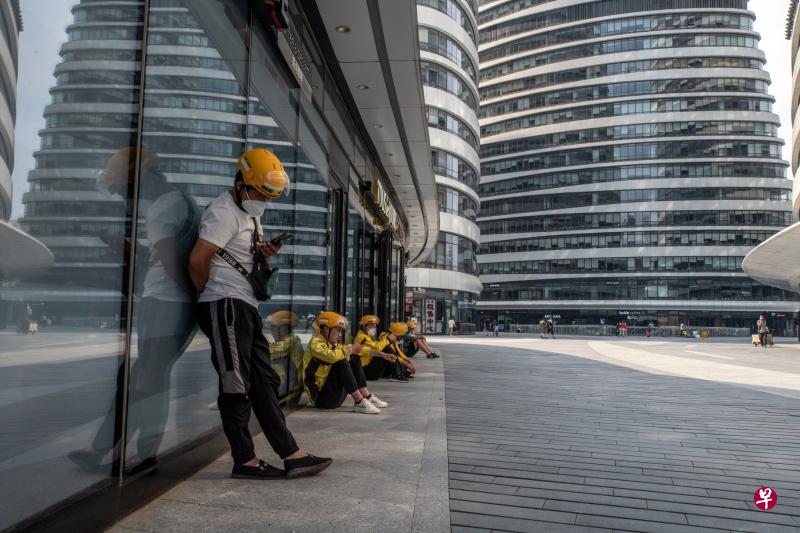 受疫情影响，中国失业状况持续攀升，官方也坦言，脱贫人口稳岗就业的压力明显加大、挑战明显增多。图为本月3日在北京市望京的一处办公楼，一群美团送餐工人在等待消费者下单。（彭博社）
