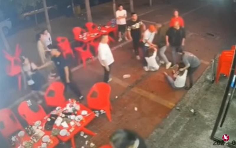 唐山一烧烤店外前天凌晨发生女子遭围殴事件，两名身穿白衣的女子被打后倒在烧烤店外的街道上。（互联网）