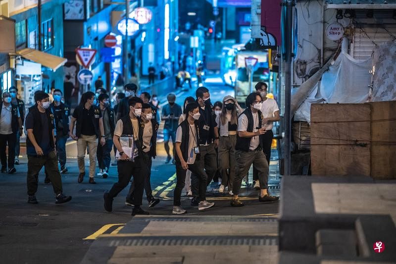 香港昨天新增1145起冠病确诊病例，包括新增一起死亡个案。图为香港警察前晚在港岛中环兰桂坊酒吧街，巡查酒吧顾客是否持有快速抗原检测阴性证明。（彭博社）