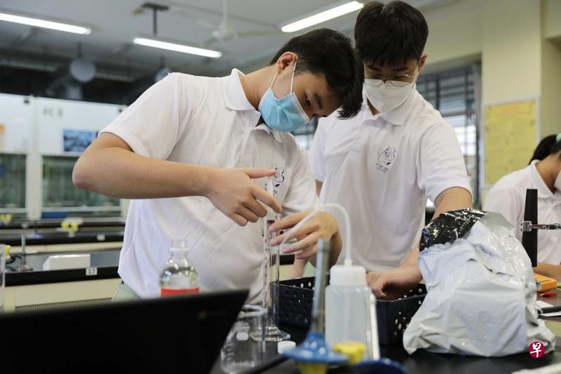 来自思励中学的林宗翰（左）与谭耀鹏在亚细安与中日韩初中科学奥德赛中进行实验挑战。（教育部提供）