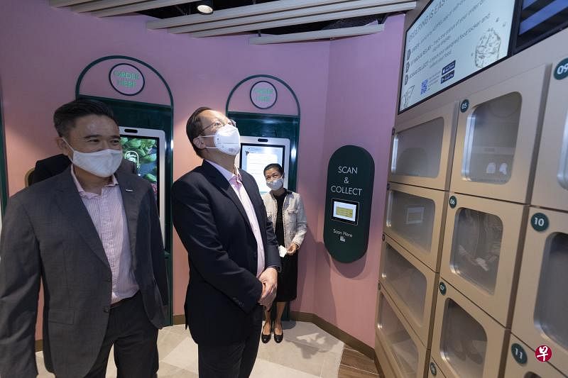 人力部长兼贸工部第二部长陈诗龙（中）在吉宝置业零售业主管刘世兴（左）的陪同下，了解i12 Katong购物中心智能点餐与派送系统如何运作；后方右为购物中心主管张美英。（陈来福摄）