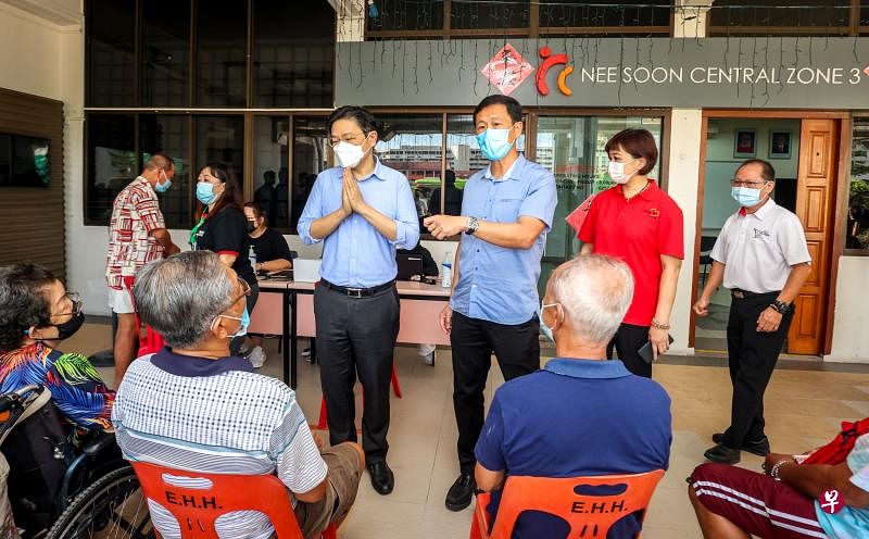 共同领导抗疫跨部门工作小组的副总理兼财政部长黄循财（面对镜头右四）和卫生部长王乙康（右三）星期一走访位于义顺中第三分区居委会的流动疫苗接种站，向居民了解他们接种疫苗的情况。（叶振忠摄）