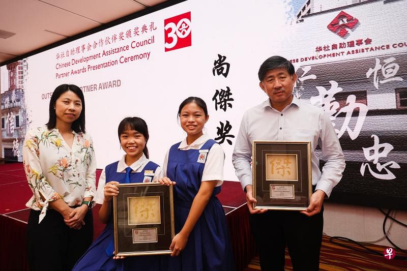 圣尼各拉女校的学生自2016年起为宏茂桥的华助会中心年长者读报；中华医院过去七年与华助会合作举办健康讲座；双双获华助会颁发尚杰奖。图为圣尼各拉女校副校长马依玲（左起）、学生林佳颖 、陈思颖和中华医院总裁许文楷。（蔡家增摄）