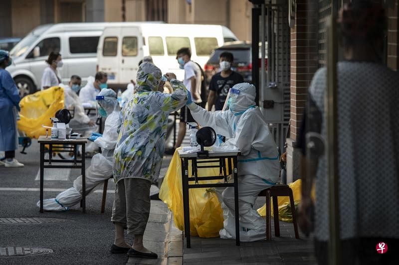 上海浦东新区发现奥密克戎BA.5变异株病例，为尽快控制疫情，当地多区从星期二起实施三天两检。图为7月10日上海一处街道居民排队等待接受核酸检测。（彭博社）