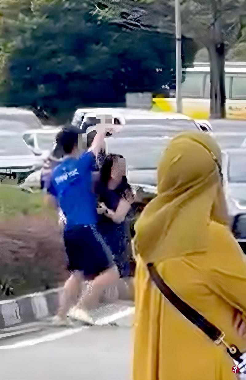 挡车女子阻拦儿子靠近多用途汽车，但他仍向对方司机比出不雅手势和飙脏话。（视频截图）