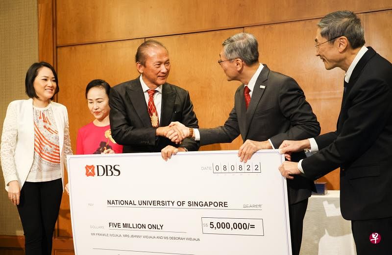 黄柏年（中）将500万元支票交给国大校长陈永财教授（右二）与国大高级副校长（卫生创新与转化）黄聿立教授（右一），以协助女皇镇保健区落实各种有助提高乐龄人士身心健康的计划。黄柏年的妻子曾妮（左二）与女儿黄德立（左一）也出席支票捐赠仪式。（李冠卫摄）