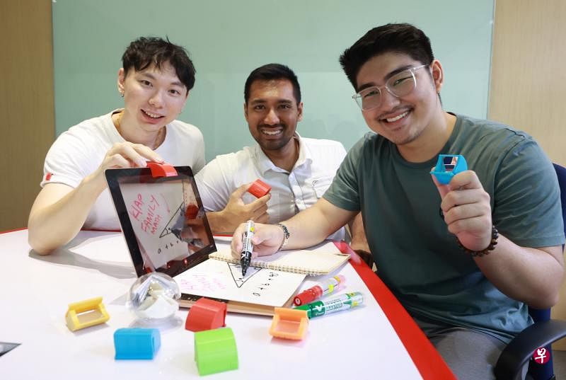新科大学三名毕业生（左起）彭懋钰、雪糕和邢庆淋，希望所研发出的投影小工具Kiap Kiap能为居家学习与远程办公的人带来更多便利。