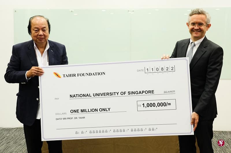 印度尼西亚富商翁俊民博士（左）在捐助仪式上将100万元“支票”交给国大法学院院长陈西文教授，协助学院增加奖学金名额以培养更多法律人才。（蔡家增摄）