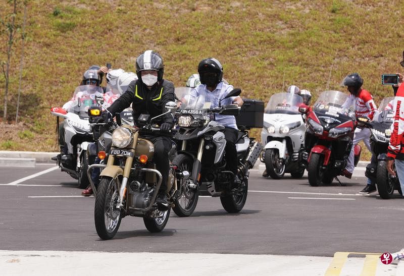 副总理兼财政部长黄循财（前）骑着电单车参加“Riders Aid”举办的慈善活动，为儿童癌症基金会筹款。（海峡时报）