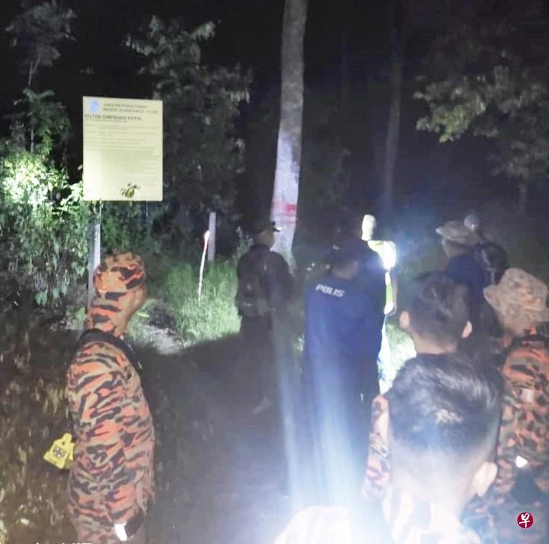 哥打丁宜警员及消拯员摸黑入山林搜寻失踪的梁添民。（柔佛州消拯局提供）