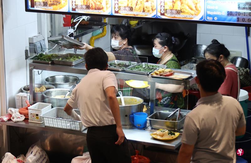 在小贩中心、咖啡店和餐馆等餐饮场所准备材料、烹煮和盛食物的人员，未来必须继续戴口罩或防飞沫口罩，以维持食品卫生。（陈渊庄摄）
