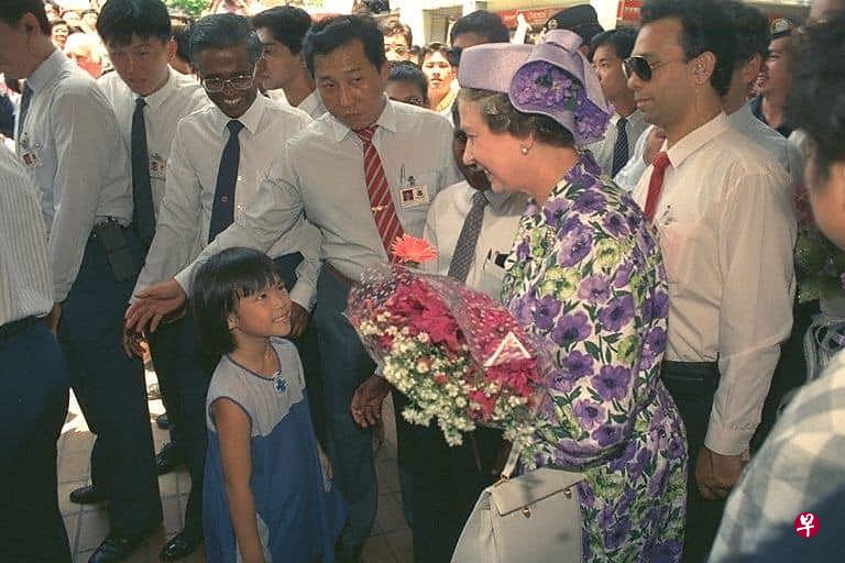 1989年英女王伊丽莎白二世第二度访问新加坡时，六岁的何廷儒与妹妹挤开人群，越过保安，向女王献花。（新加坡国家档案馆）