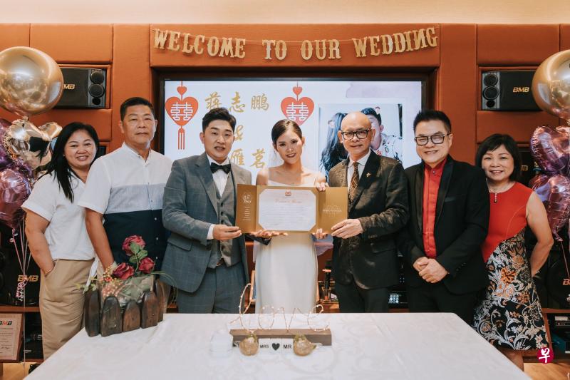 蒋志鹏（左三）和庄雁茗（左四）在证婚人卓顺发（右三）和张仰兴（右二）的祝福下，在Teo Heng门市店注册结婚。（受访者提供）