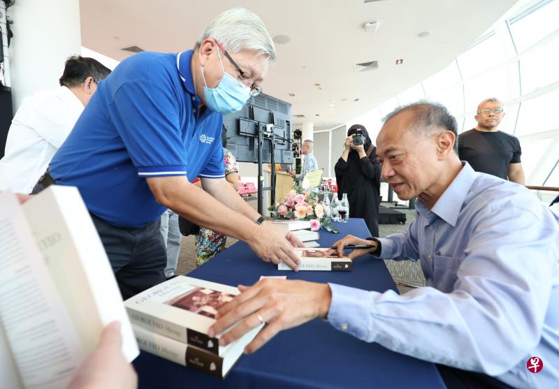 前外交部长杨荣文（右）在新书“George Yeo：Musings”的发布会现场为购书的朋友签名。（何家俊摄）