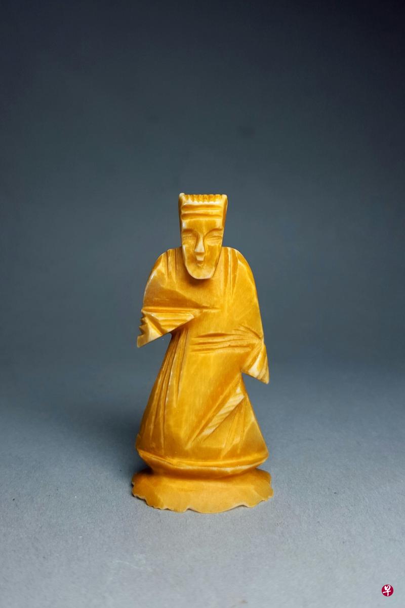 ↓→陈信中为牛骨西洋棋刻上钱龙（壁虎）图案。
