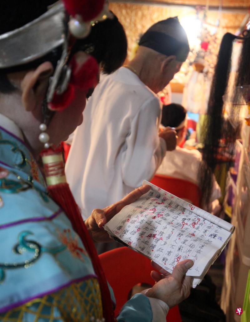 演员花了两小时上妆和穿戴行头后，争取在开锣前再背一遍手抄剧本上的剧情。