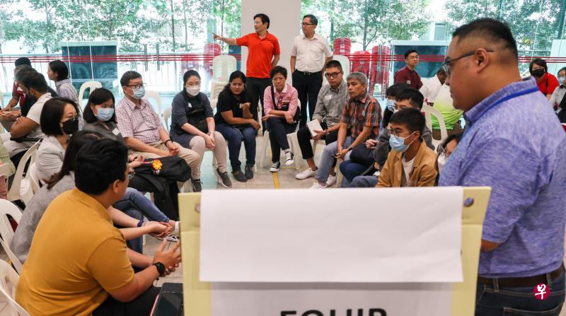 136名公众参加了在油池民众俱乐部举行的“新加坡携手前进”运动社区对话。他们先是针对不同课题进行小组讨论，之后向到场的副总理兼财政部长黄循财（站着红衣者）、西北区市长任梓铭（站着白衣者），以及其他参与者简短汇报小组的建议。（卓祾祎摄）