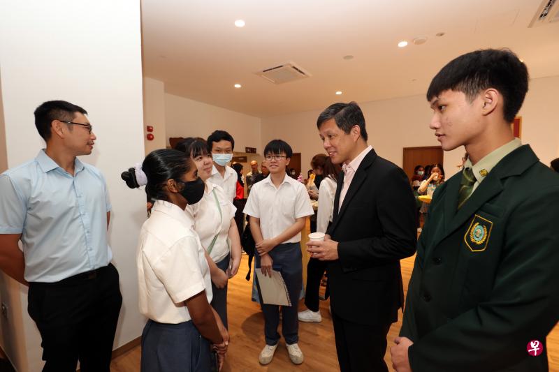 教育部长陈振声（右二）与新加坡佛教居士林教育基金大专组助学金得主交流；右一为精进奖得主黄相维。（邝启聪摄）