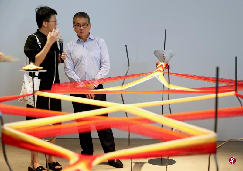 文化、社区及青年部长兼律政部第二部长唐振辉（右）为新加坡双年展揭幕观展时，聆听双年展艺术总监之一叶德晶讲解挪威萨米族艺术家Elina Waage Mikalsen的作品。（龙国雄摄）