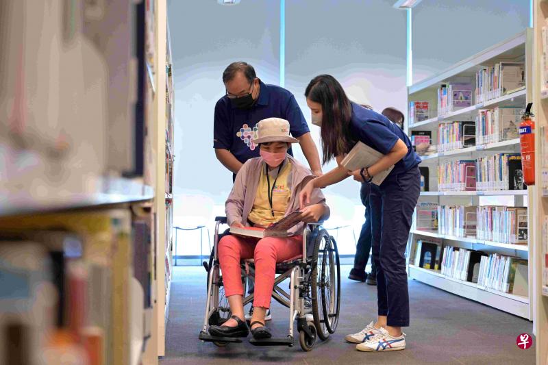 两名策安保安机构职员日前参与活动，协助SPD的受益者借书。（策安提供）