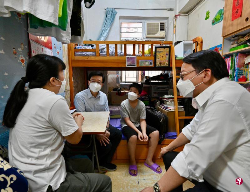 香港特首李家超（左二）今年7月到访深水埗区，在政务司司长陈国基（右一）陪同下，探访住在劏房的基层家庭。（香港特区政府新闻处）