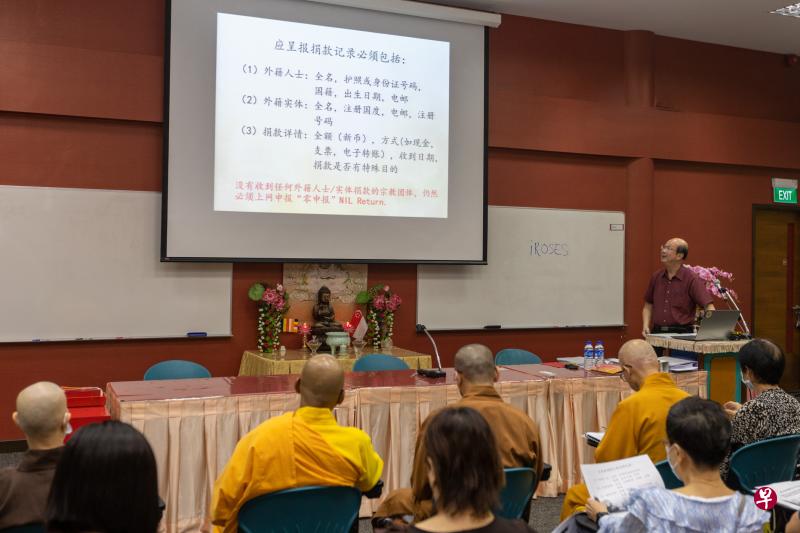 新加坡佛教总会执行长柯孙科（面向镜头者）把维持宗教和谐法令的新条例重点翻译成华文，在说明会上讲解宗教团体须在何时，以及如何依法申报资料。（张思庆摄）