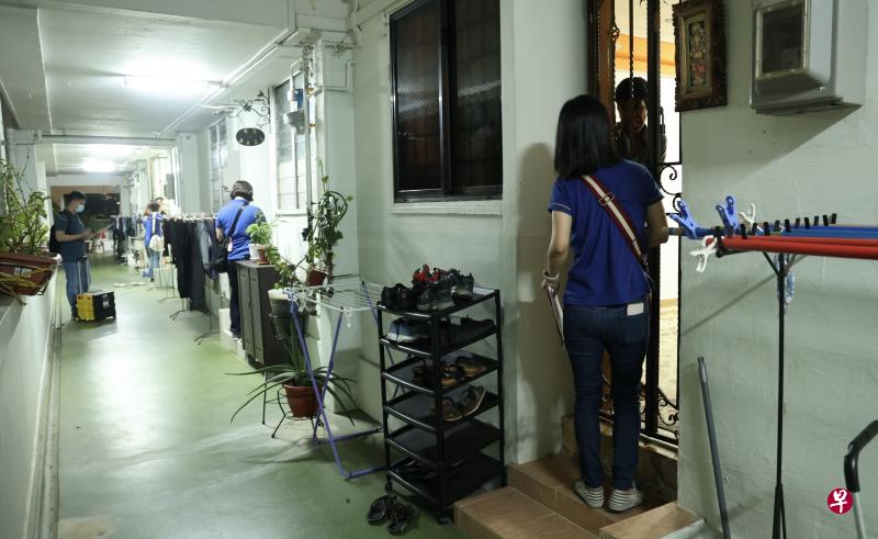 建屋发展局人员星期三晚上在宏茂桥3道第562座至565座组屋挨家逐户，向受选择性整体重建计划影响的居民说明实际赔偿额。（邬福梁摄）