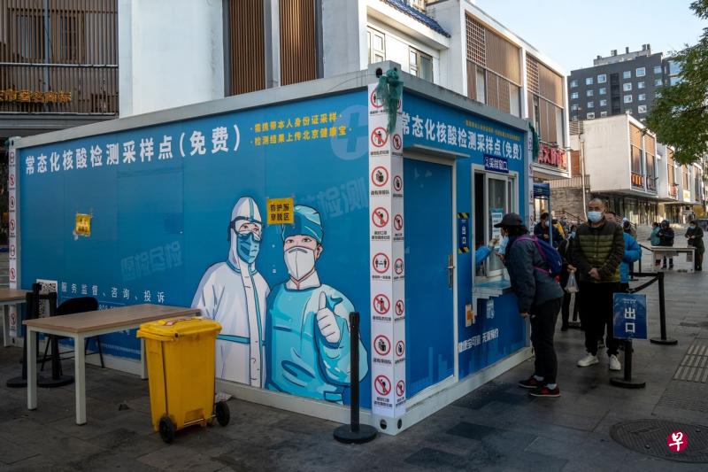 中国在11月11日宣布优化疫情防控20项措施，对“动态清零”政策做出重大调整，但各地不断上升的疫情再次带来新的挑战。图为北京居民在11月14日排队接受核酸检测。（彭博社）