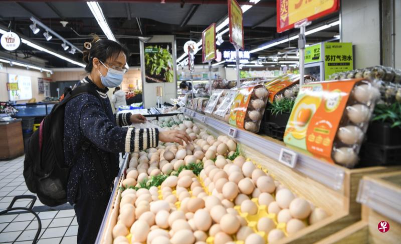 重庆部分地区近期进一步收紧封控措施，在每户每两天可派一人外出就近采购的基础上，要求外出者限时两小时返回到小区，否则可能无法进入小区。图为一名重庆市民11月12日在超市选购鸡蛋。（新华社）