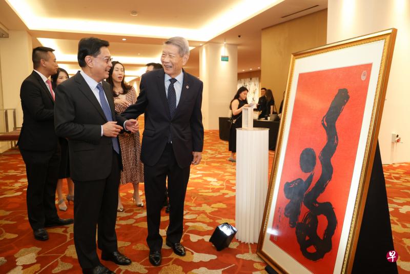 副总理兼经济政策统筹部长王瑞杰（左）与新加坡儿童会主席许俊辉在儿童会70周年慈善筹款晚宴上，一同欣赏即将拍卖的艺术品。（李冠卫摄）