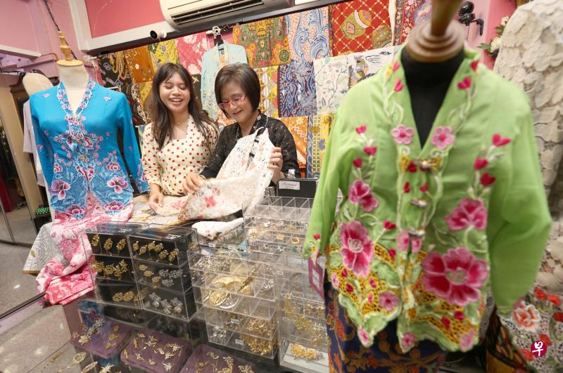 拉蒂亚娜（右）经营卡峇雅服饰店近20年，女儿普特丽从小就在店里帮忙，如今协助母亲打理生意。拉蒂亚娜说，女儿小时候就开始穿卡峇雅，长大后不仅以穿卡峇雅为傲，也鼓励朋友多穿这个传统服装。（何家俊摄）