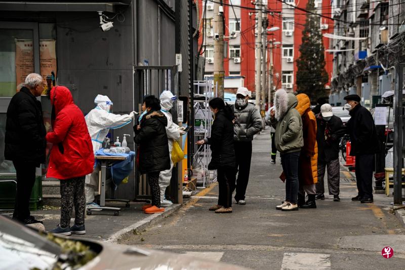《人民日报》星期二刊登评论文章，警告核酸检测乱象已到了“非重典不能止乱的时候”，称这将严重消减公众对核酸检测的公信力。图为北京一处被封控住宅区，居民在星期二排队接受核酸检测。（法新社）
