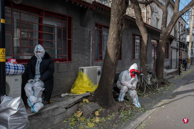 中国国家卫生健康委官员星期二强调，封控管理要快封快解、应解尽解，减少因疫情给民众带来的不便。图为当天两名防疫人员在北京一处被封控的居民小区把守。（彭博社）