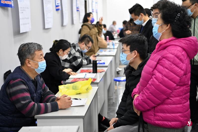 从事一份安稳的本业同时兼职其他工作，成为近年来一些中国年轻人的新就业形态。图为今年11月12日求职者在山西省会太原市招聘会现场与用人单位工作人员交流。（新华社）