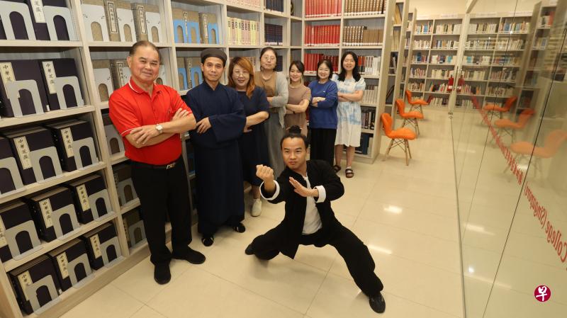 韮菜芭城隍庙的三清道教图书馆藏有1万本典籍。后排左起：城隍艺术学院院长陈添来、道乐团导师黄信成道长、三清宫总经理王爱丽、道教学院学术主任吉凌、城隍艺术学院行政管理沈惠珊、副教育经理杨詠心和道教学院学术助理韩欣楠。前排是武当城隍道教养生院总教练王晓利。（邬福梁摄）