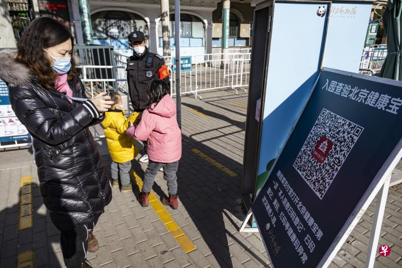 北京市12月6日宣布从当日起市民进入各类公共场所，可不查验核酸检测阴性证明，扫码进入即可。图为市民进入北京动物园前，在入口处扫描“北京健康宝”QR码。（中新社）