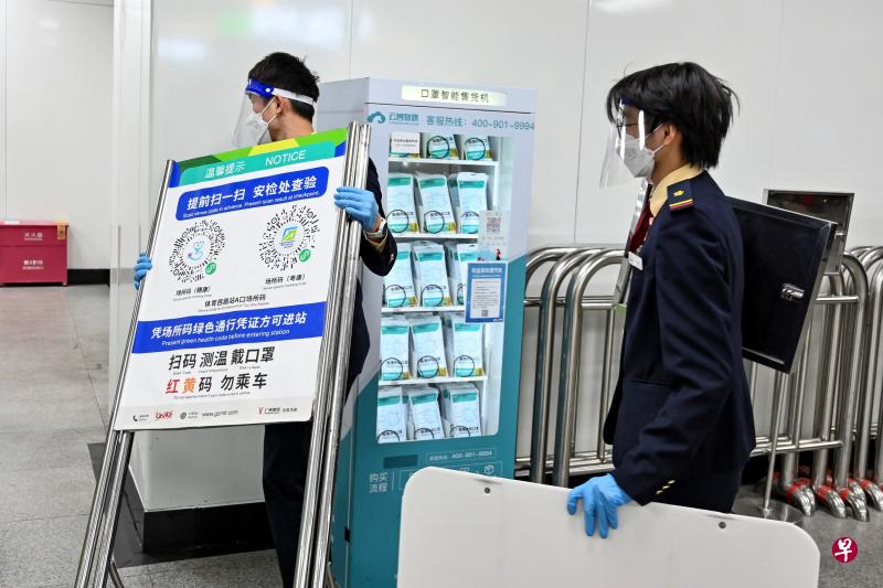 中国官方宣布，公众无需核酸检测证明或出示健康码，即可进入公共场所及乘坐公共交通工具。图为广州铁路工作人员星期三（12月7日）拆除车站扫描健康码的告示。（路透社）