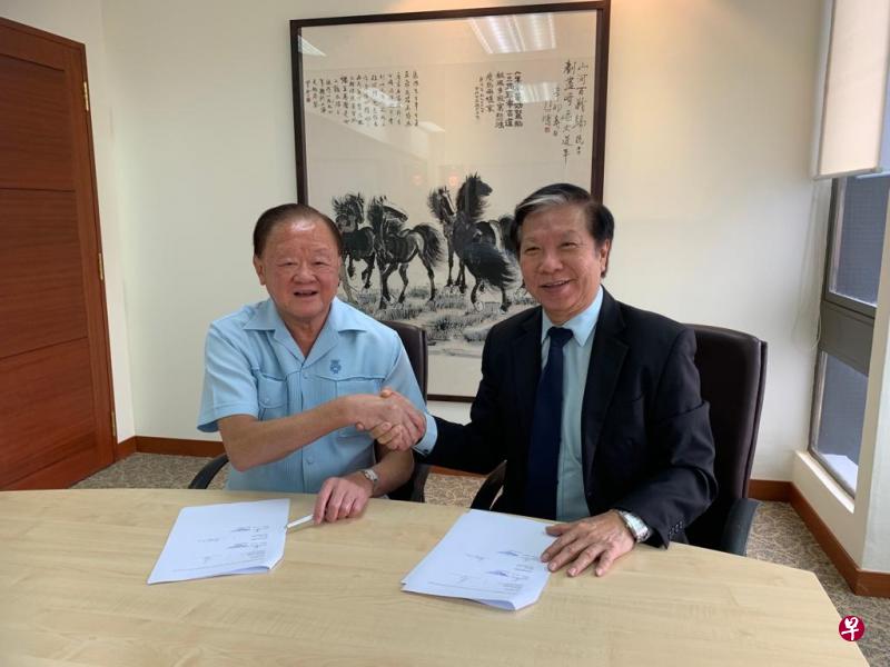 富商黄鸿年（左）和智慧控股集团总裁林焕章在签署新股配售协议后，双方握手致意。（智慧控股提供）