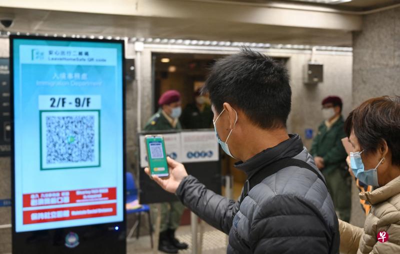 香港市民12月13日进出各个场所时仍须使用“安心出行”手机应用扫描二维码，但从12月14日开始再也不用这么做。（法新社）